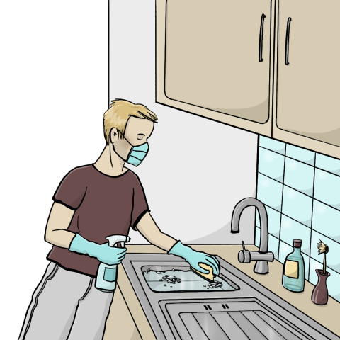 Eine Person trägt Mundschutz und Handschuhe und desinfiziert Flächen in der Küche