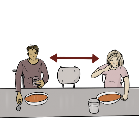 2 Personen sitzen an einem Tisch und essen Suppe. Zwischen ihnen ist ein Sitzplatz frei.